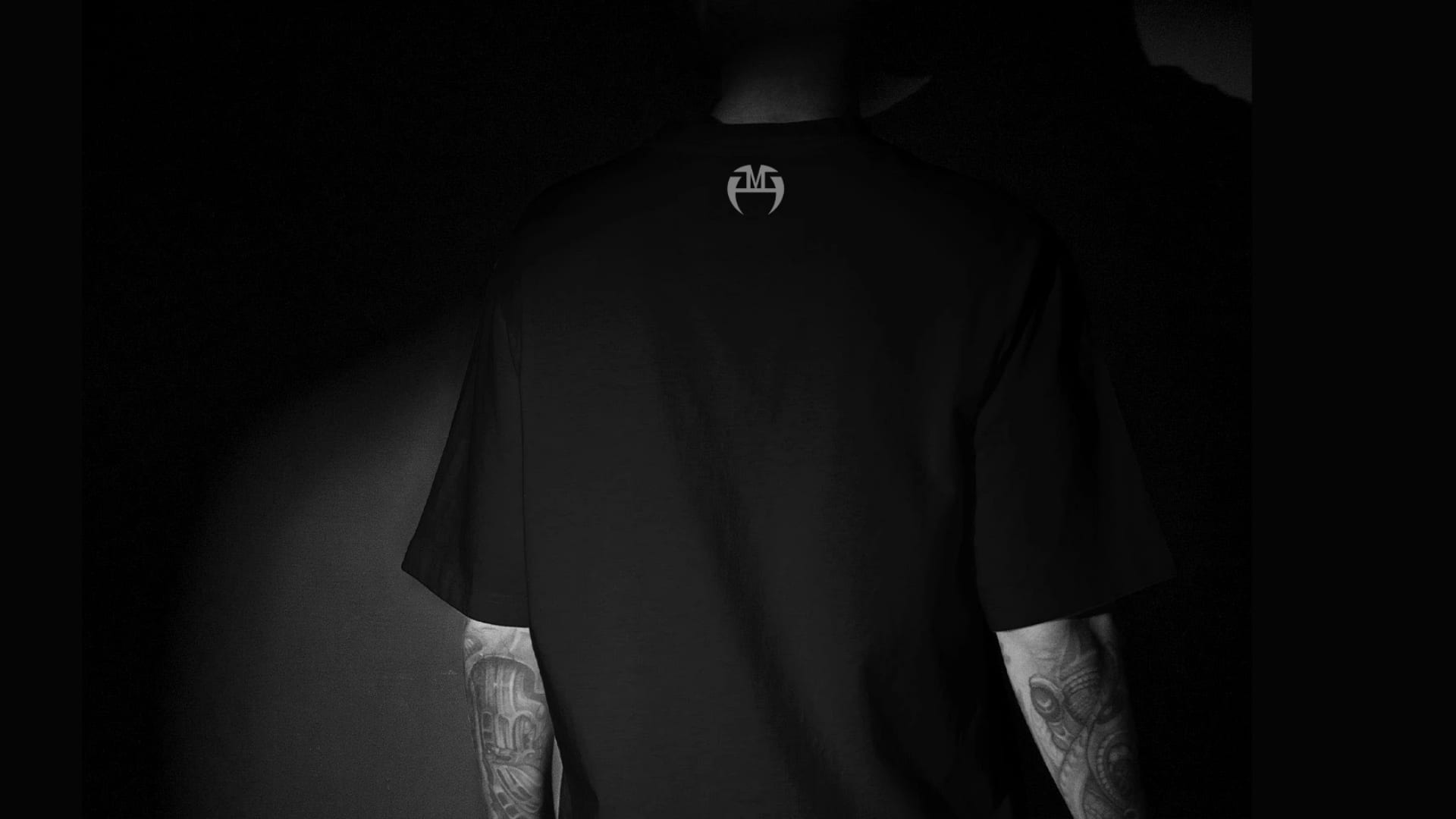 Back of a black t-shirt with a small Andi Malaj Rage mark