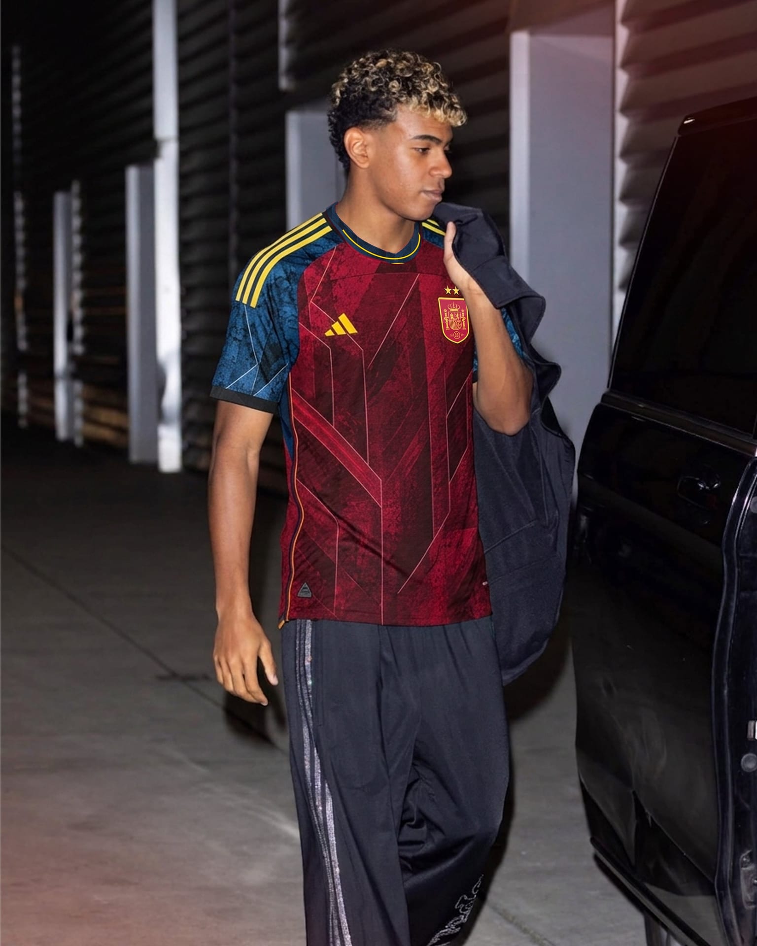 Person wearing the Spain home kit beside a car at night