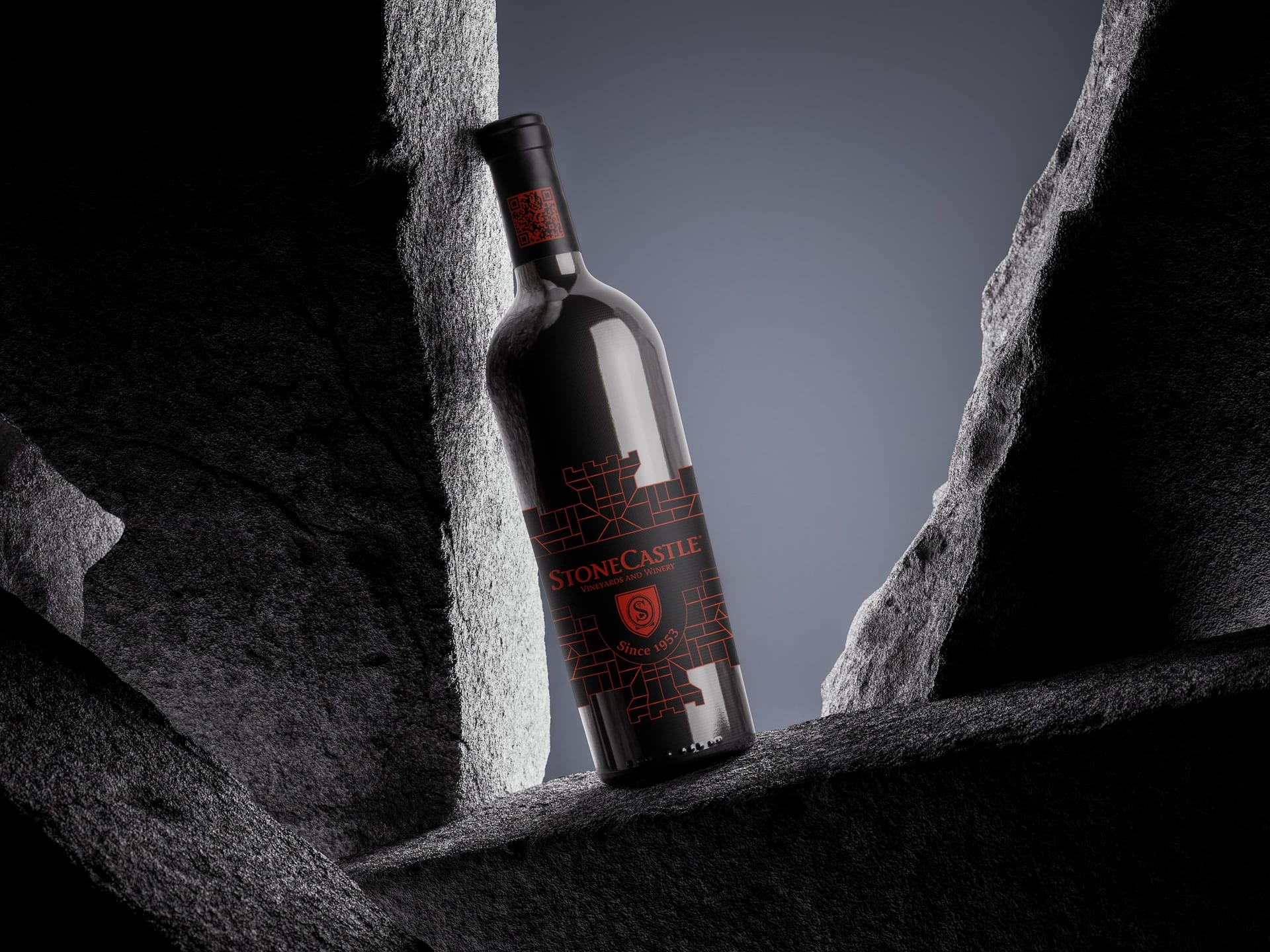 StoneCastle bottle leaning in a gap between dark rocks